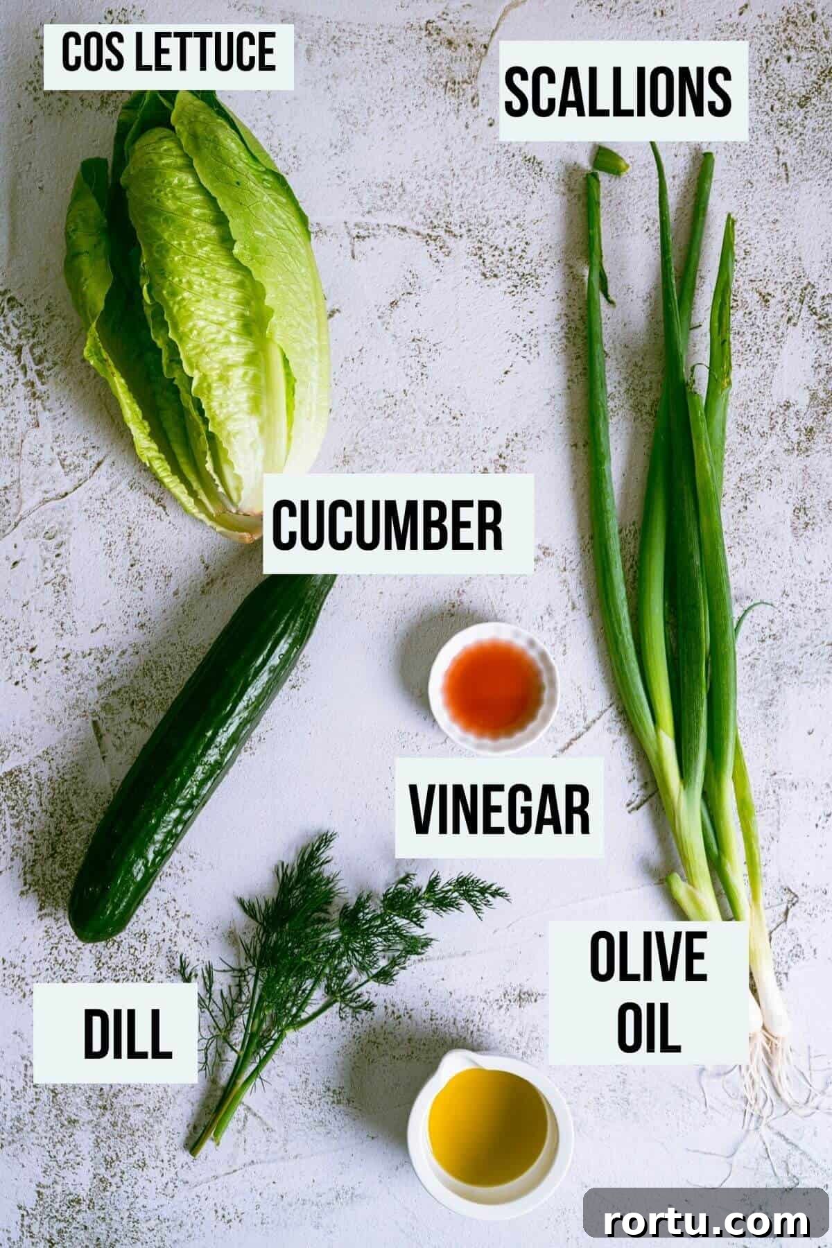a grey table with ingredients to make Greek lettuce salad.