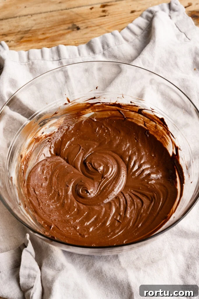 Whipped chocolate and butter mixture inside a large mixing bowl.
