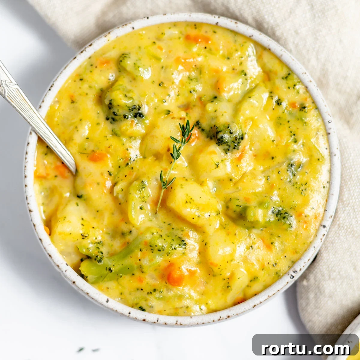 Creamy Broccoli, Potato & Cheddar Soup Recipe 2 Broccoli Potato Cheese Soup in a bowl with a spoon.