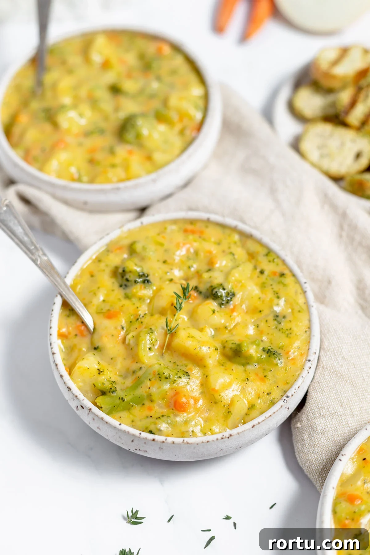 Creamy Broccoli, Potato & Cheddar Soup Recipe 11 Two bowls filled with broccoli potato cheese soup.