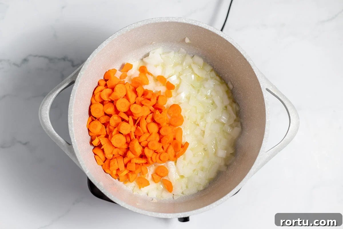 Creamy Broccoli, Potato & Cheddar Soup Recipe 5 Carrots are added to the onions in the stock pot.