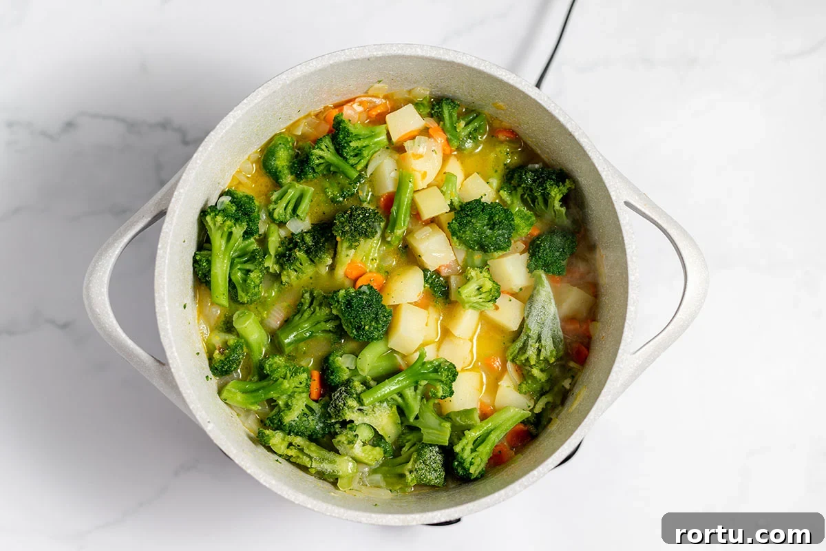 Creamy Broccoli, Potato & Cheddar Soup Recipe 7 Broccoli added to soup in the stock pot.