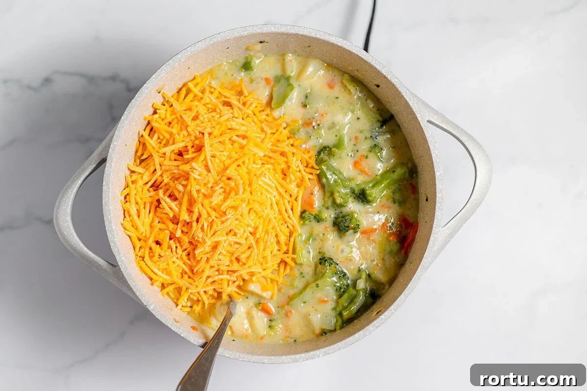 Creamy Broccoli, Potato & Cheddar Soup Recipe 8 Shredded cheese added to soup in stock pot.