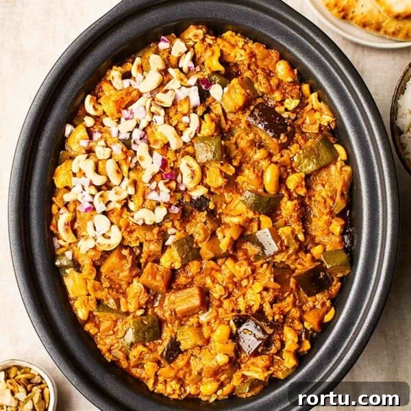 Vegetarian slow cooker curry in a slow cooker topped with cashew nuts.
