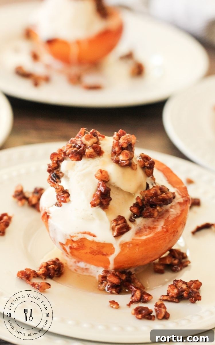 caramelized peaches topped with vanilla ice cream and toasted pecans on a white plate