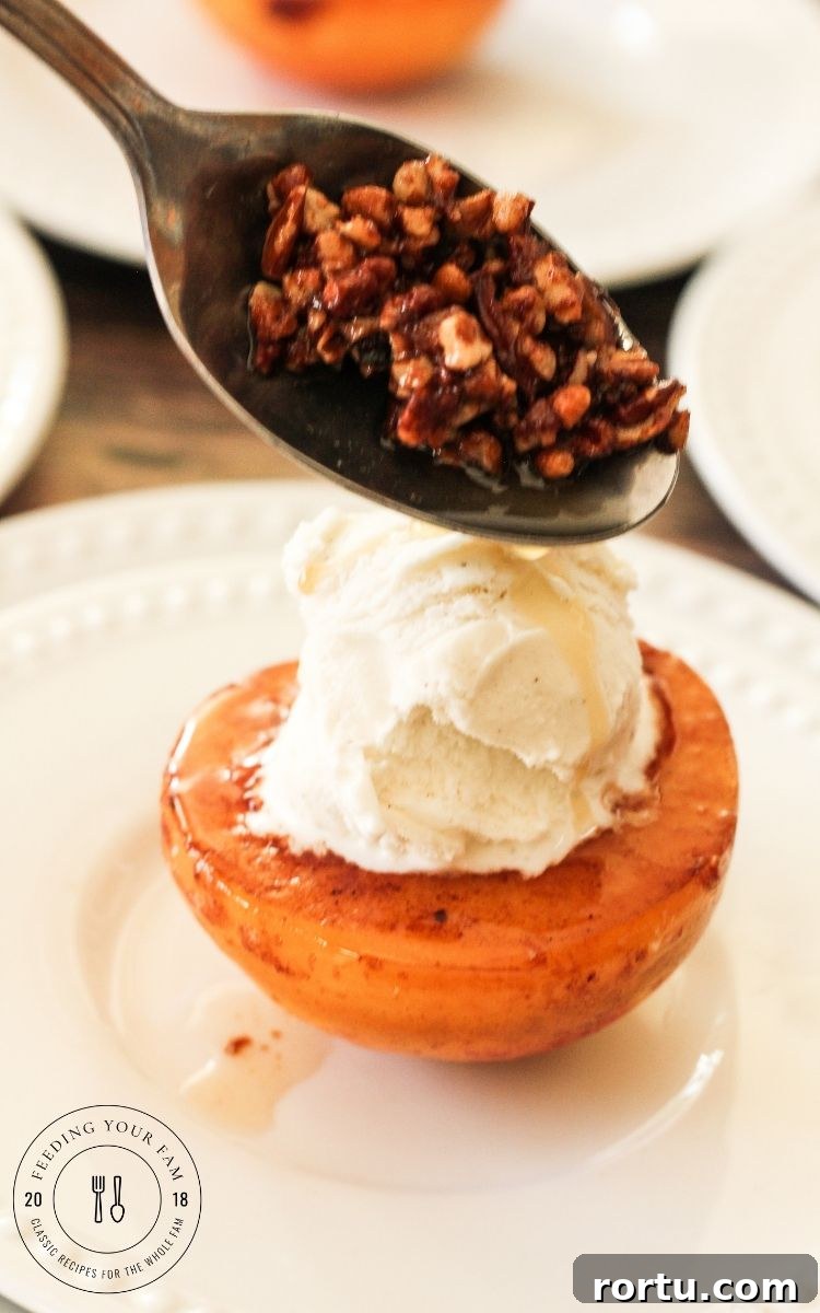 spooning toasted pecans over a caramelized peach topped with vanilla ice cream