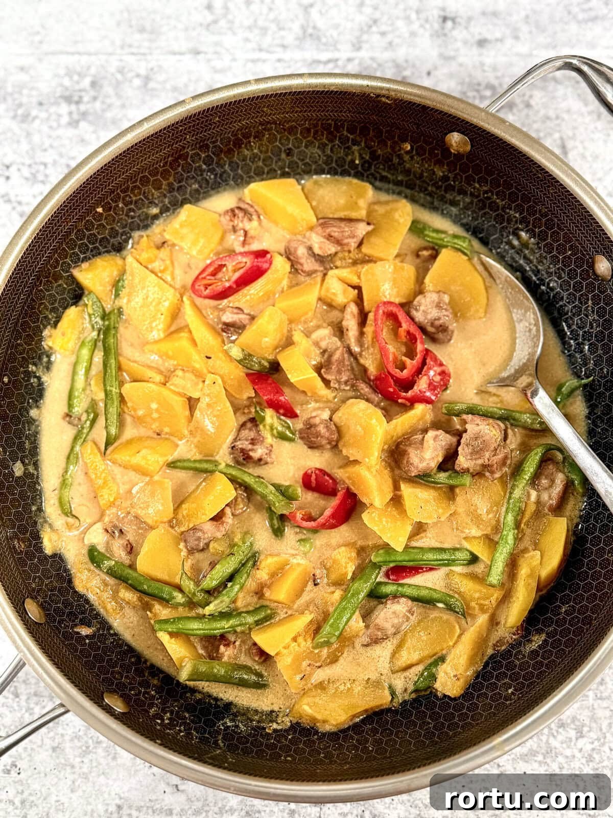 Sauteed Butternut Squash with Pork (Ginisang or Ginataang Kalabasa) in wok