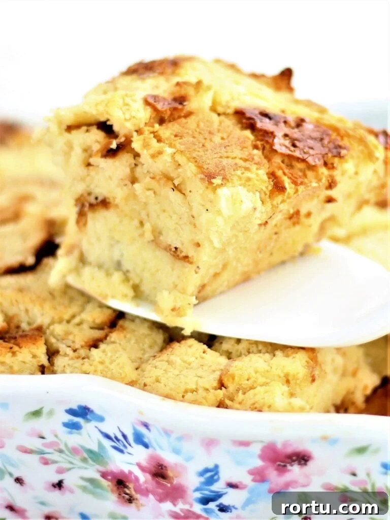 Gluten-Free ʻOhana Bread Pudding Recipe – Hawaiian Comfort Dessert 3 cutting a big slice of bread pudding with white spatula