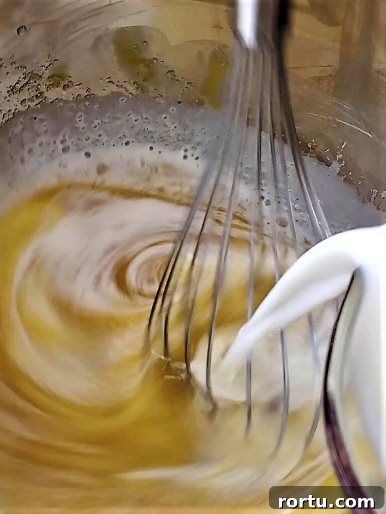 Gluten-Free ʻOhana Bread Pudding Recipe – Hawaiian Comfort Dessert 6 pouring milk into egg mixture