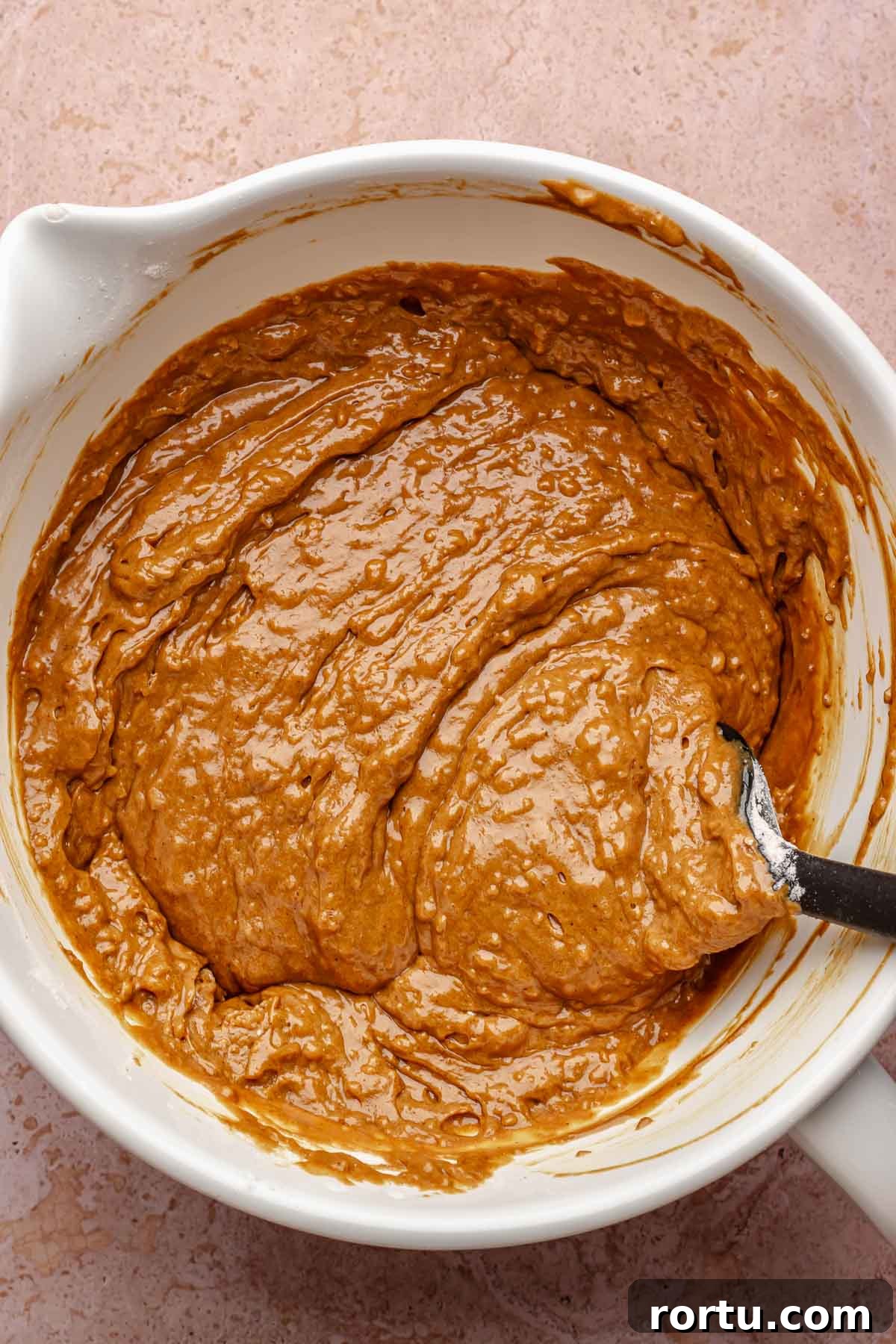 Mixed gingerbread muffin batter in a bowl.