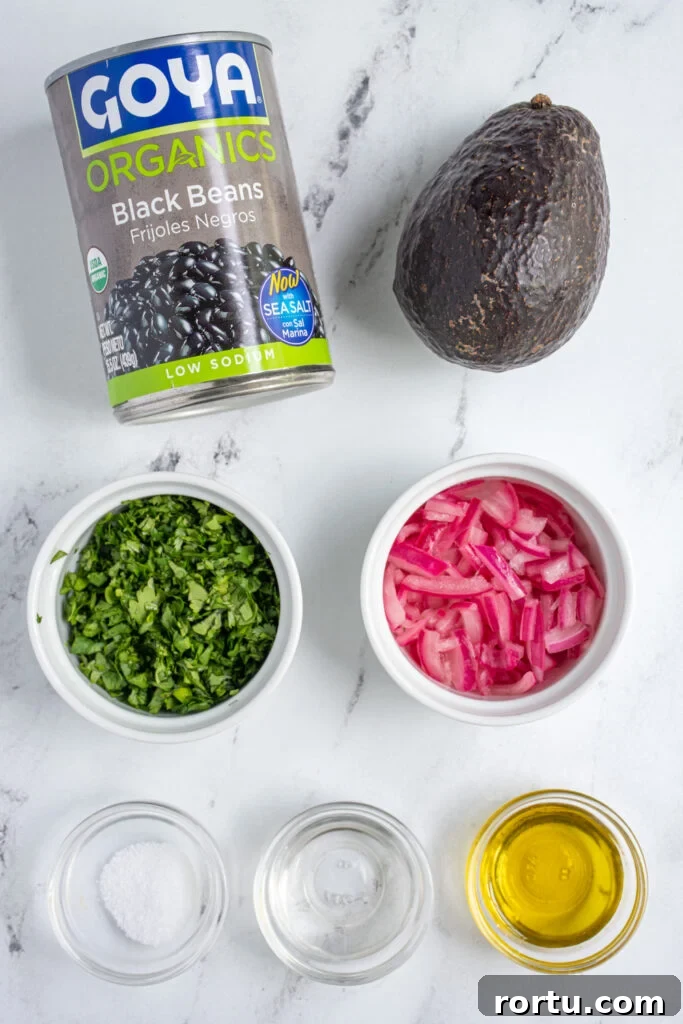 Ingredients needed to make avocado black bean salsa laid out on a tabletop.
