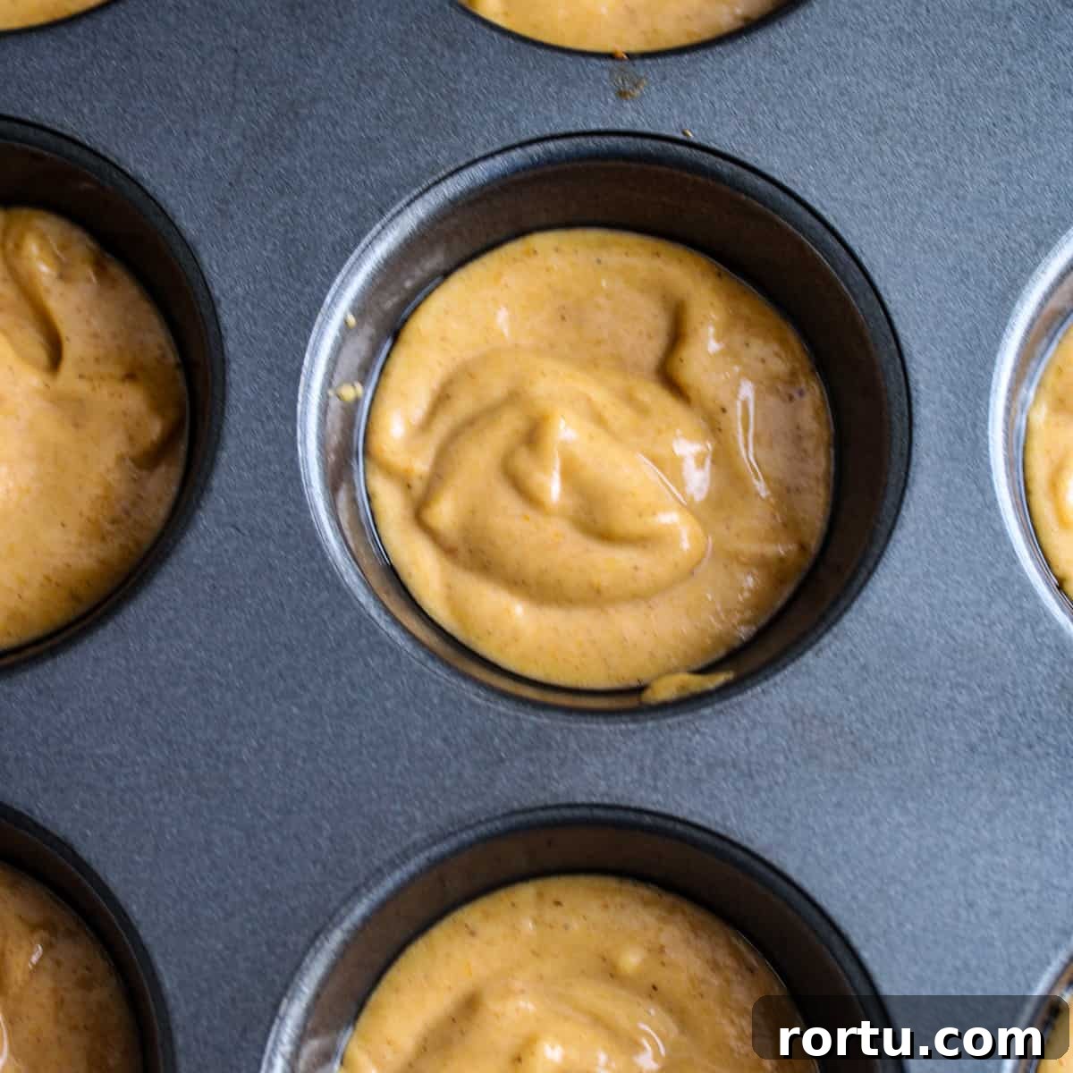 Batter in a greased muffin tin.