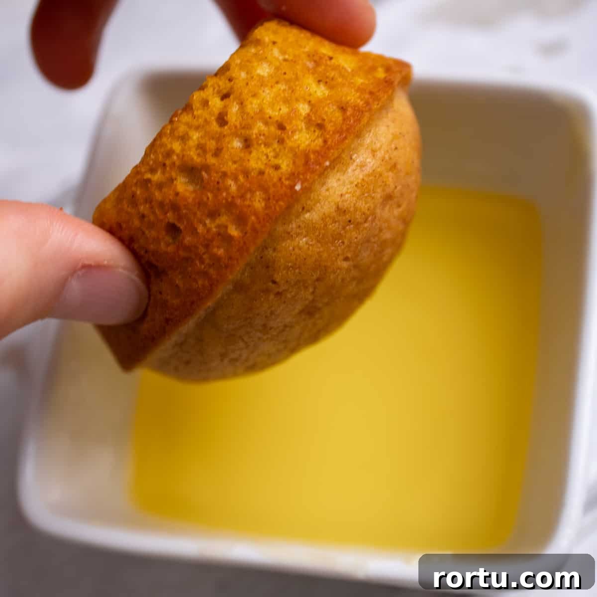 Dipping the muffin into melted butter.