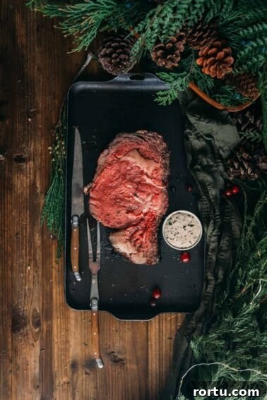 Tender Slow-Roasted Eye Round: Juicy, Melts in Your Mouth 12 A slice of smoked prime rib on a black tray with a knife and fork.