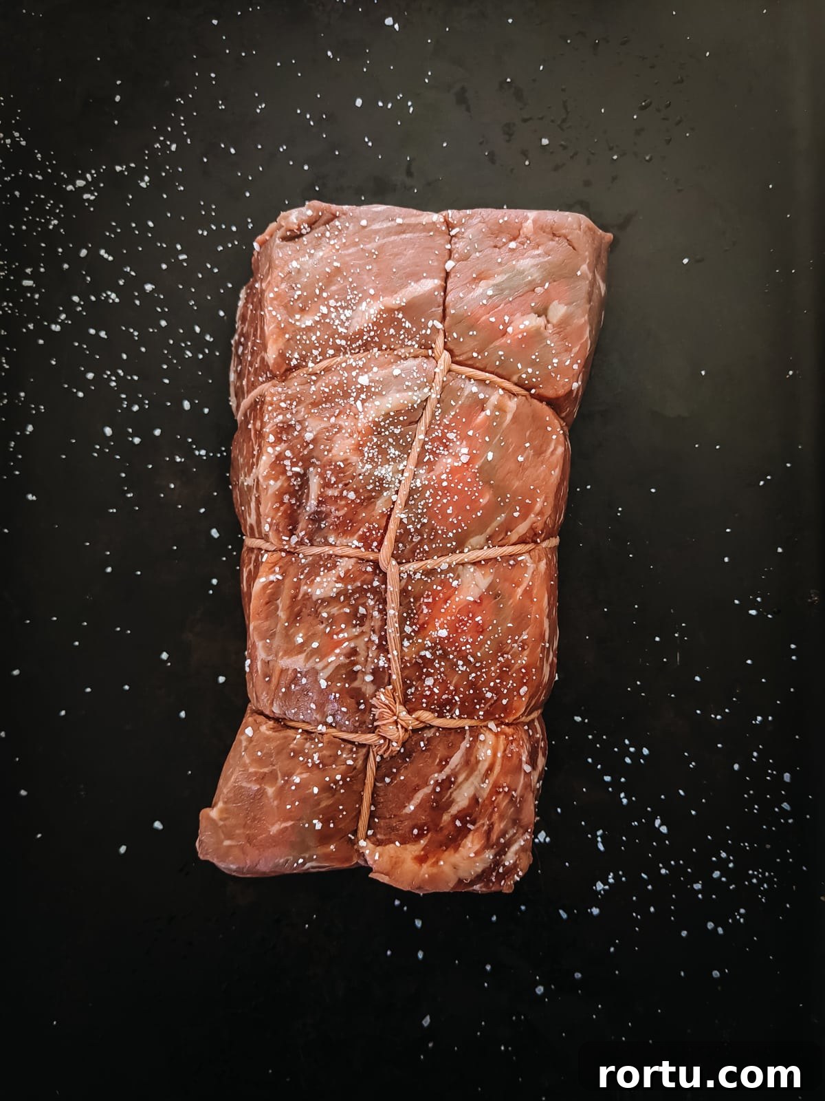 Tender Slow-Roasted Eye Round: Juicy, Melts in Your Mouth 3 Raw eye of round roast seasoned with salt.