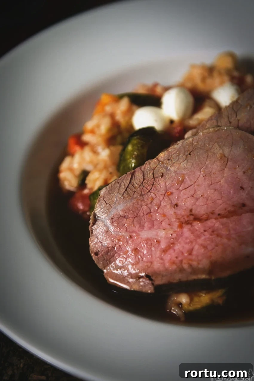 Tender Slow-Roasted Eye Round: Juicy, Melts in Your Mouth 9 Sliced eye round roast on a white platter over risotto