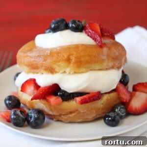 Strawberry Shortcake with a Grown-Up Twist 3 Close up of a Doughnut Strawberry Shortcake topped with fruit on a white plate.