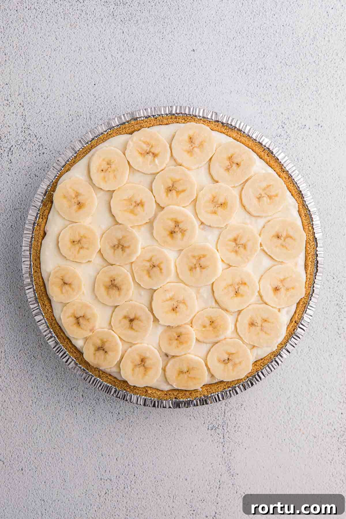 Banana slices layered over creamy filling in a graham cracker crust.