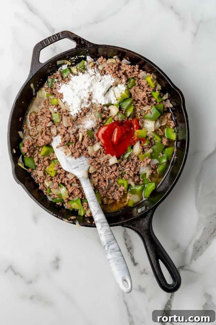 Philly Cheesesteak Sloppy Joes Recipe — Savory Sandwich Twist 5 adding in remaining ingredients to the sloppy joes