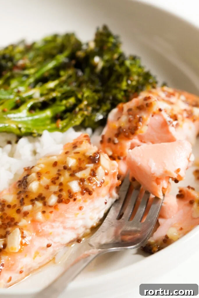 Maple Mustard Baked Salmon Recipe for Tender Glazed Fillets 2 fork taking a bite of maple mustard salmon