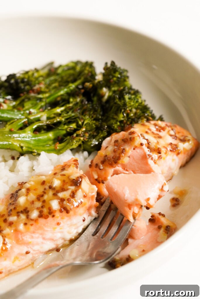 Maple Mustard Baked Salmon Recipe for Tender Glazed Fillets 15 fork taking a bite of baked salmon