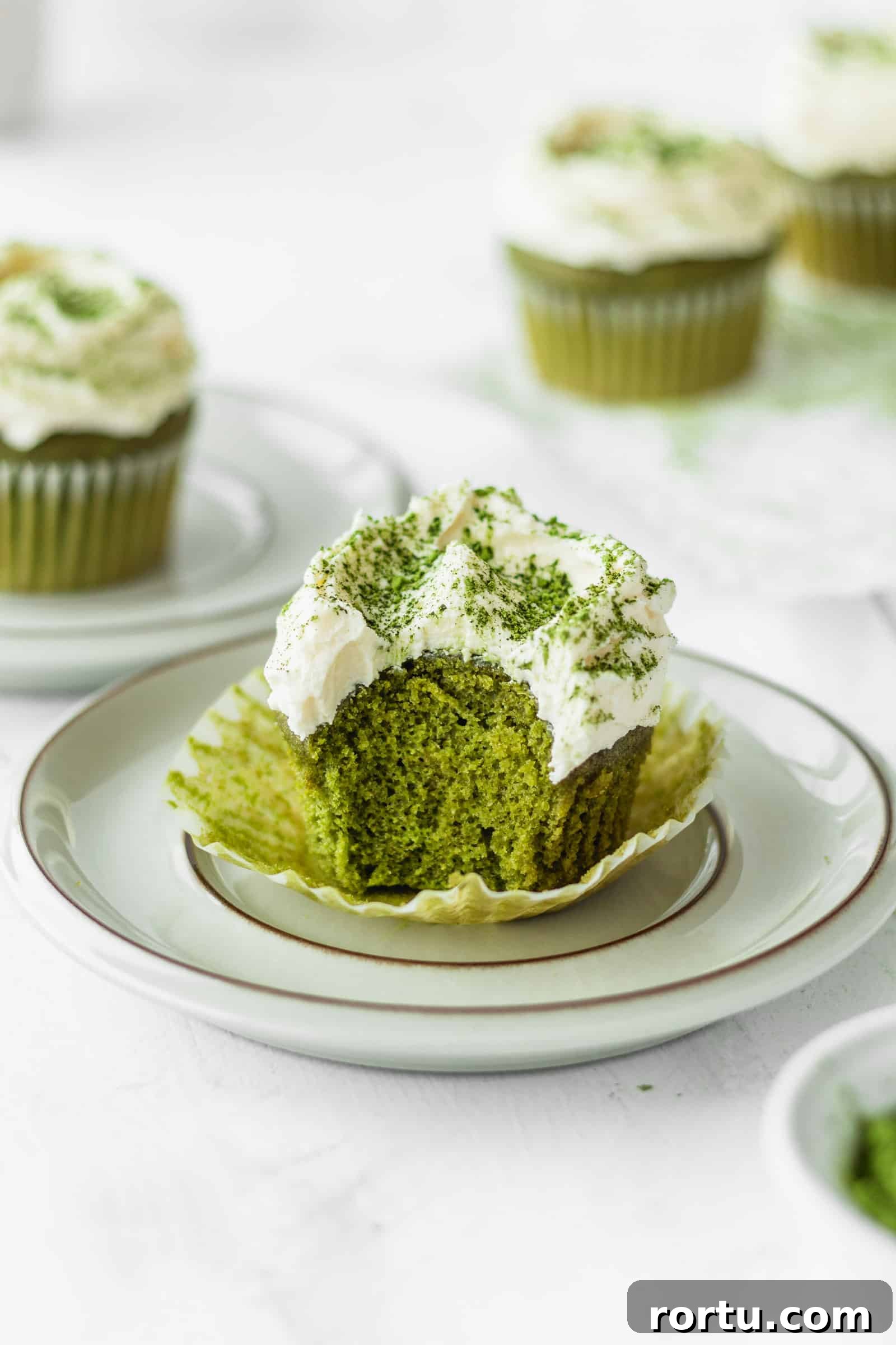 Fluffy Matcha Cupcakes: How to Make Moist Green Tea Cupcakes (Video) 11 Fluffy green tea cupcake with a bite taken out