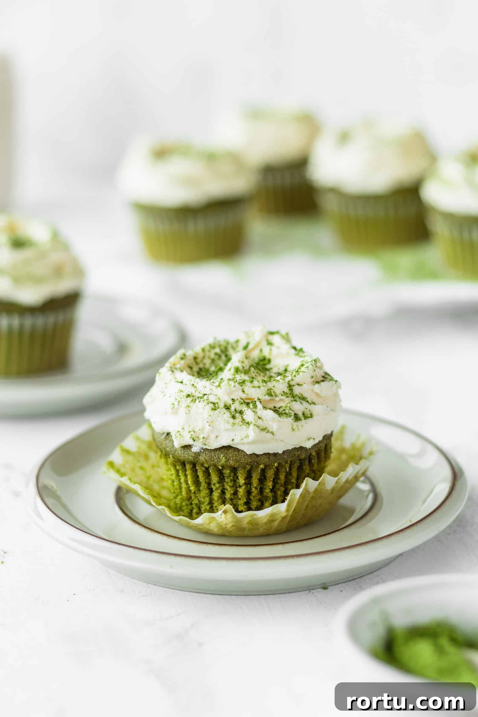 Fluffy Matcha Cupcakes: How to Make Moist Green Tea Cupcakes (Video) 9 Green tea cupcake being unwrapped on a plate