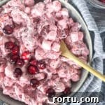 Close up of Cranberry Fluff Salad in bowl with light bluish background