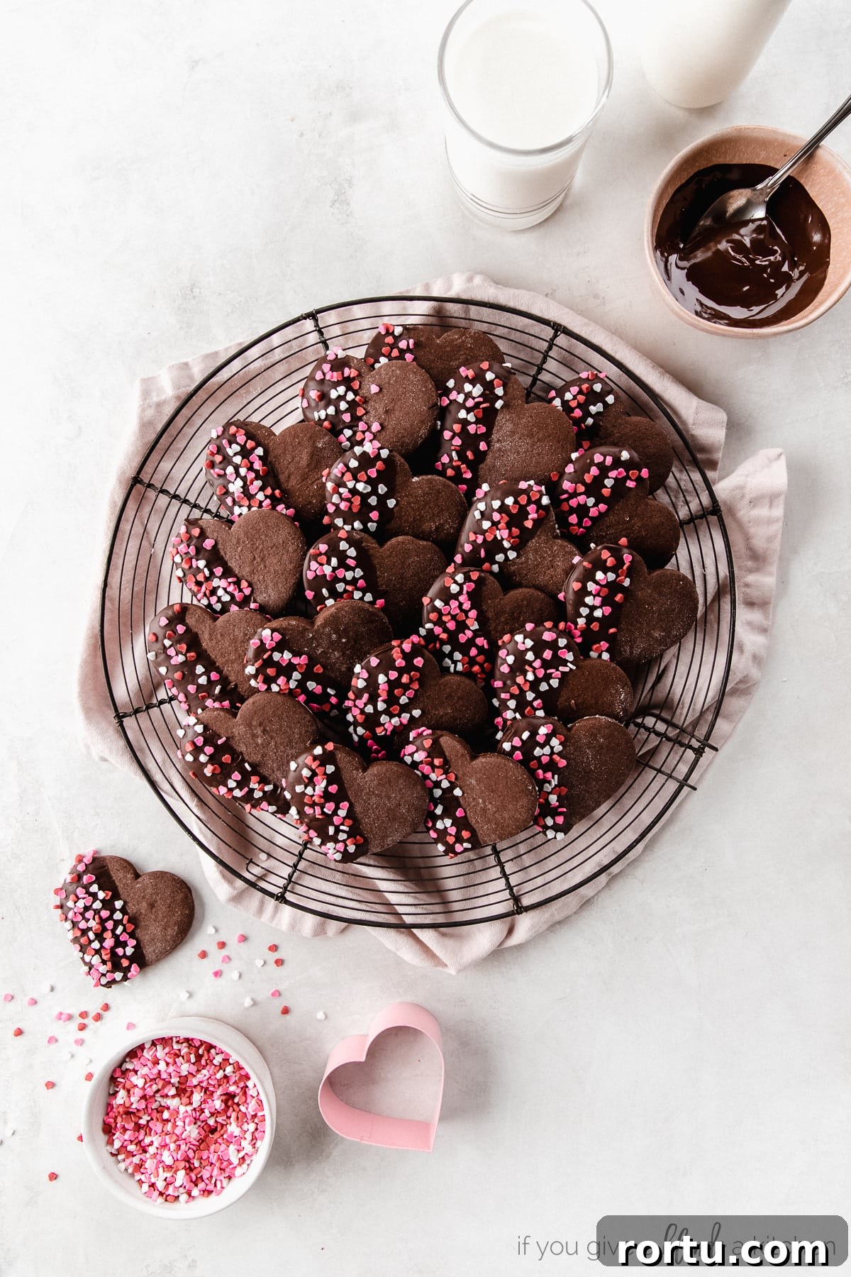 Chocolate Cut-Out Cookies: Perfect Decorated Cocoa Sugar Cookies 7 chocolate heart cookies with melted chocolate and red and pink sprinkles on round wire cooling rack