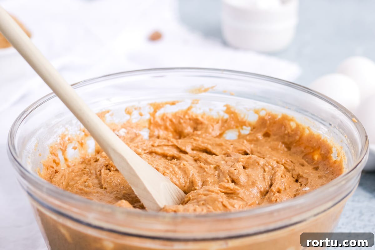 A mixing bowl full of batter for a pumpkin cream cheese pound cake. 
