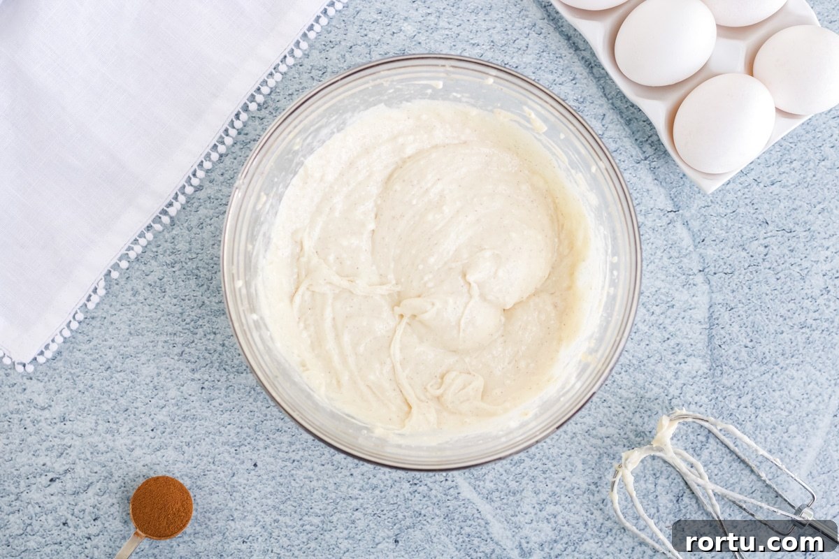 A bowl full of a cream cheese mixture for pumpkin cream cheese pound cake. 