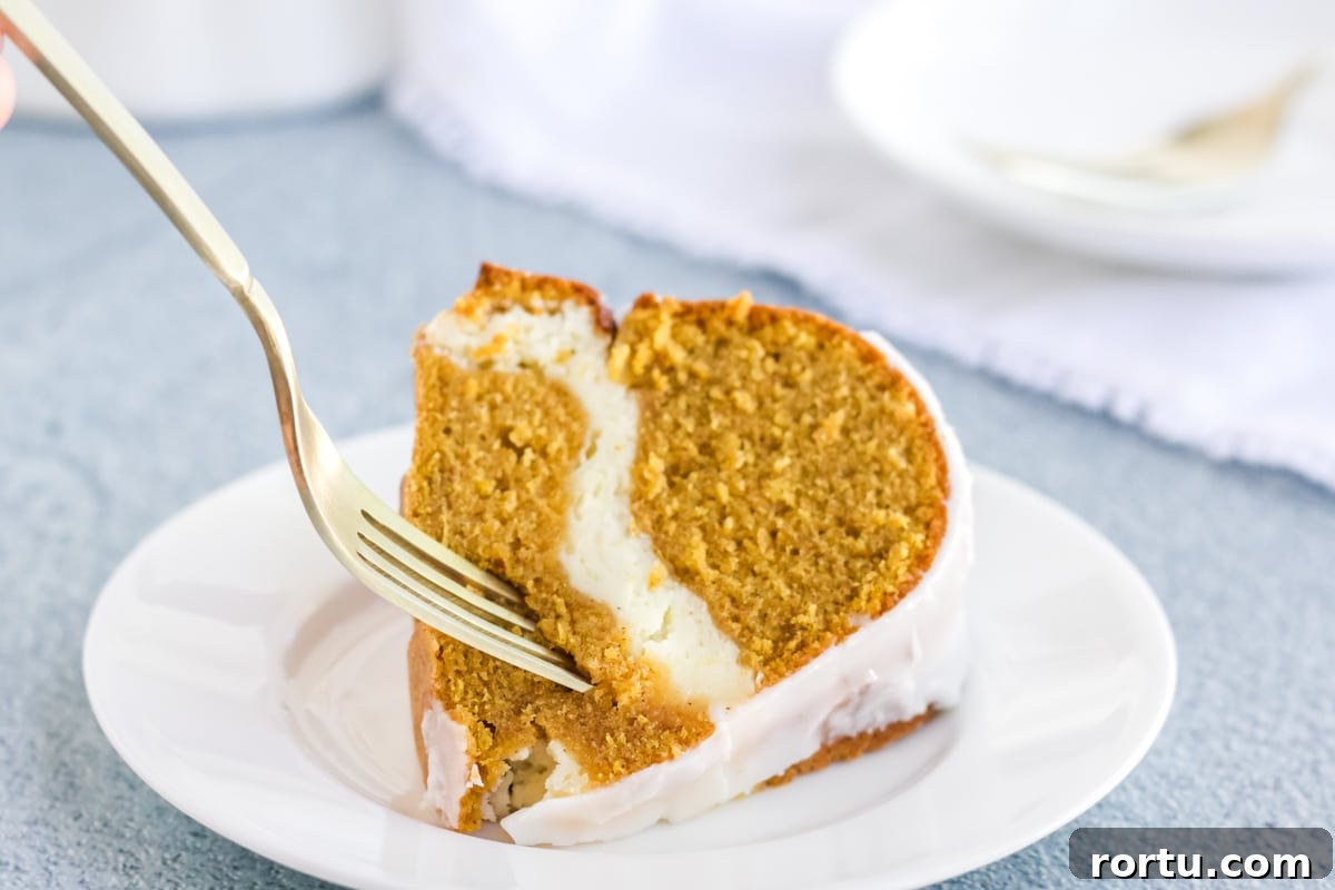 Cream Cheese Pumpkin Pound cake on a white plate with a fork going in for a bite.