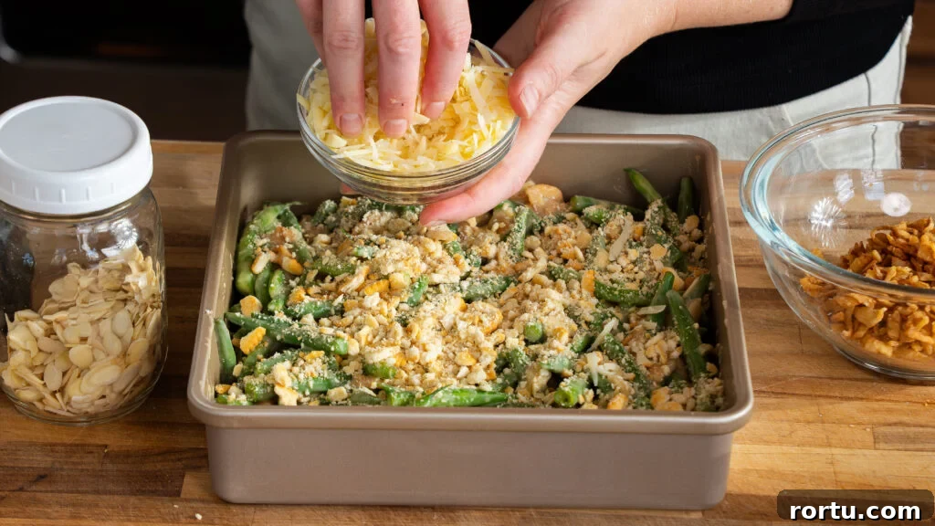 Adding cheese to the top of a green bean casserole.