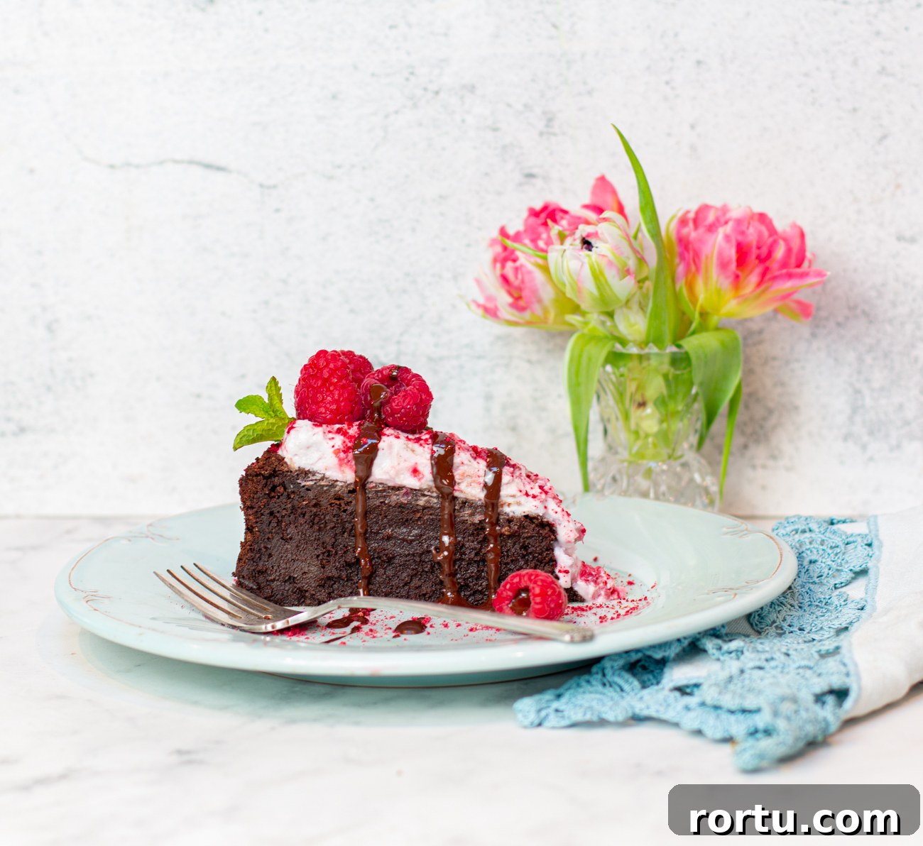 Flourless Chocolate Mousse Cake with Raspberry Coconut Whipped Cream 8 A slice of the cake with a chocolate drizzle