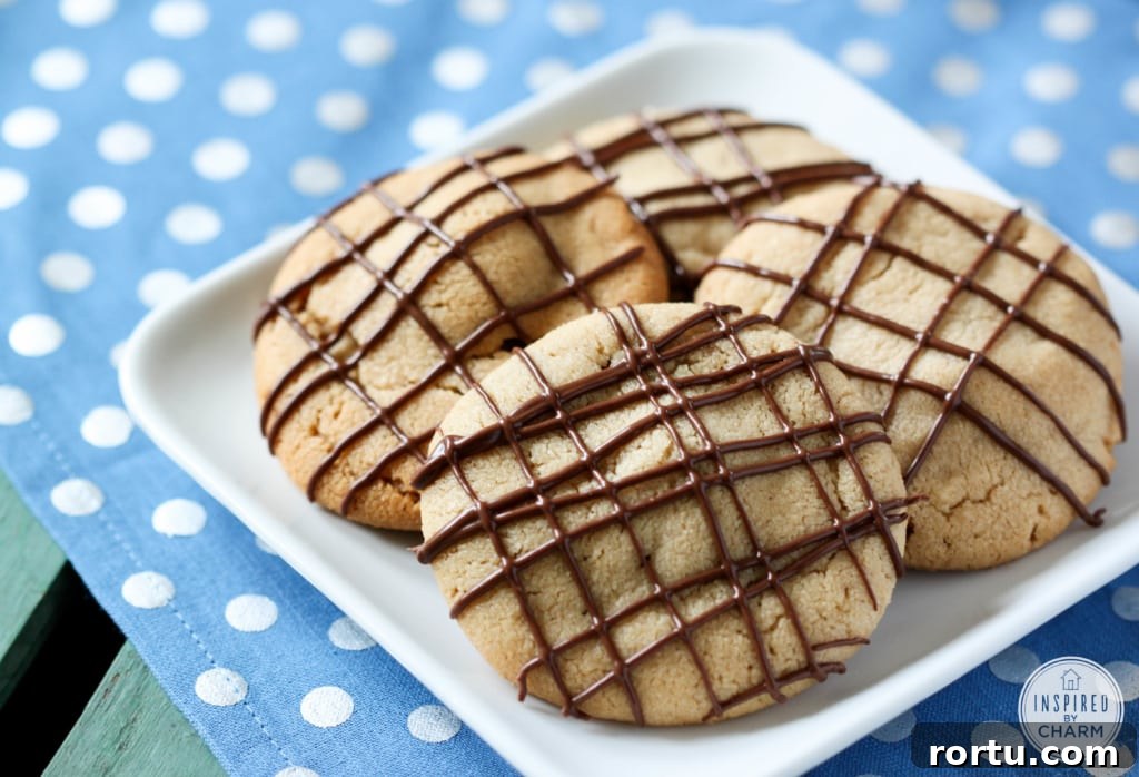 four stuffed peanut butter cookies on a white plate.
