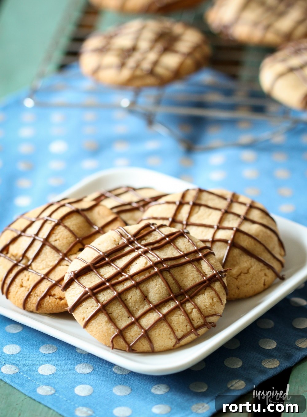 stuffed peanut butter cookies on a plate on a blue polka dot napkin.