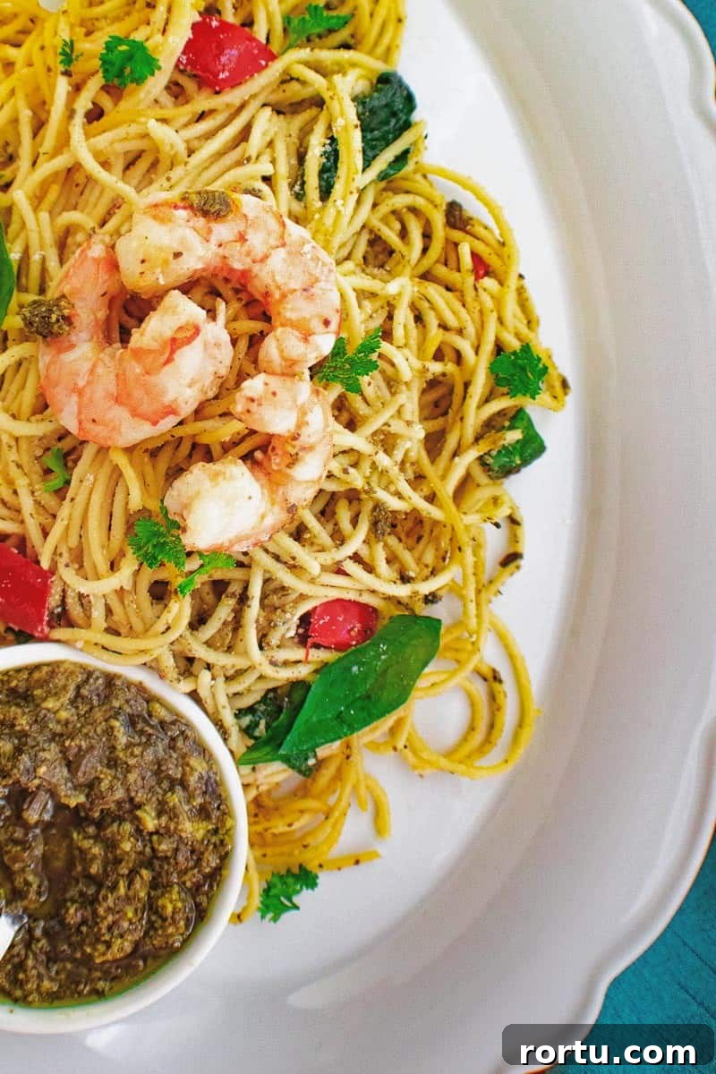 Shrimp pesto pasta on white serving platter.