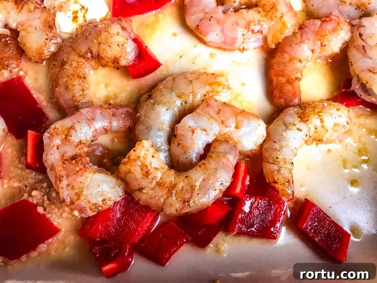 Seasoned shrimp, red bell pepper, garlic and butter in pan.