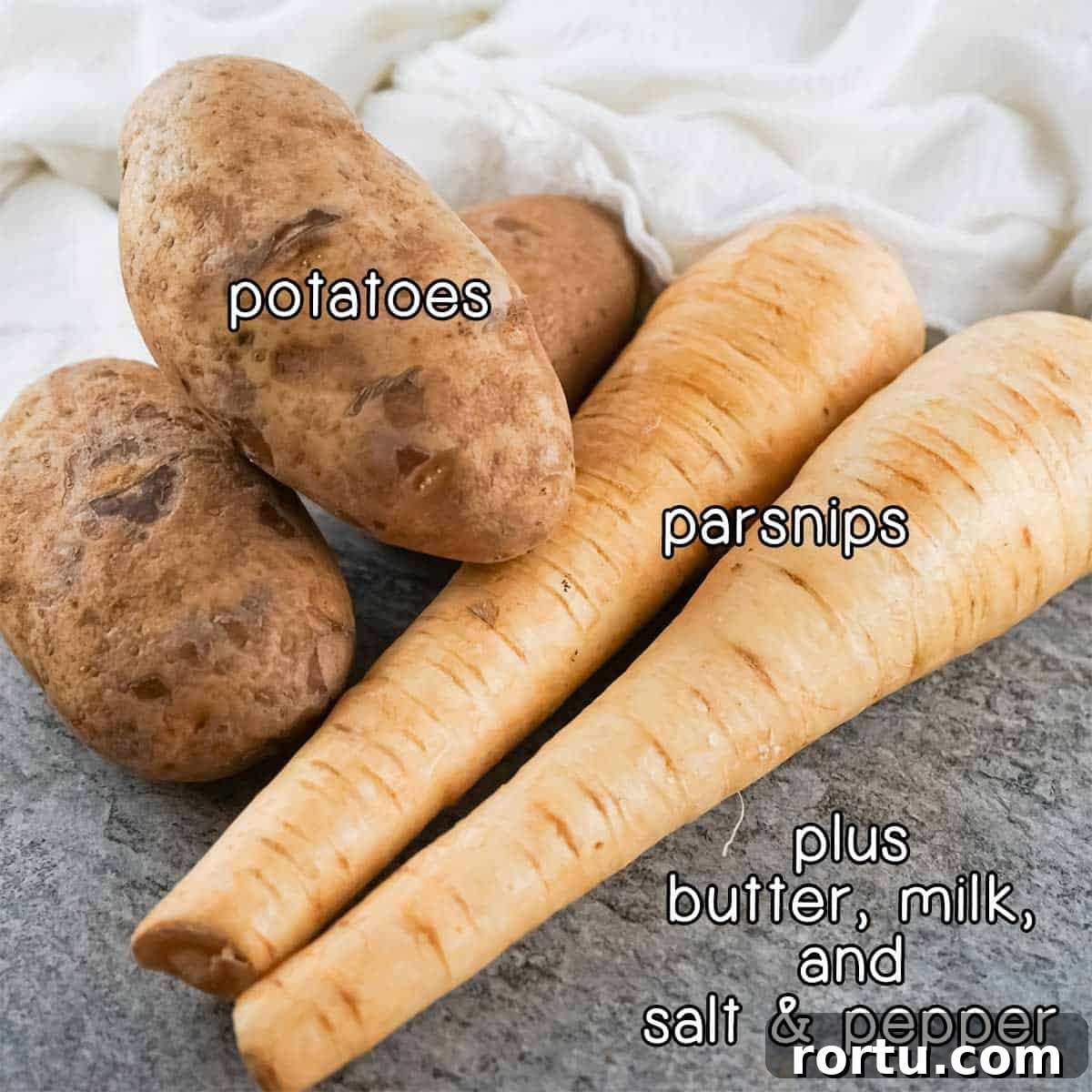 Side view of ingredients- potatoes and parsnips, plus butter, milk, and salt and pepper.