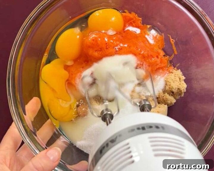 Ultimate Carrot Cake with Light Fluffy Cream Cheese Frosting 8 combine eggs sugar and carrots for carrot cake