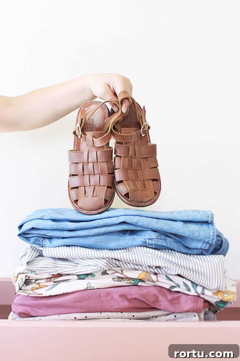 Summer Kids Capsule Wardrobe + Free Printable Checklist 7 a neat pile of matching pastel dresses for girls and a pair of brown leather shoes