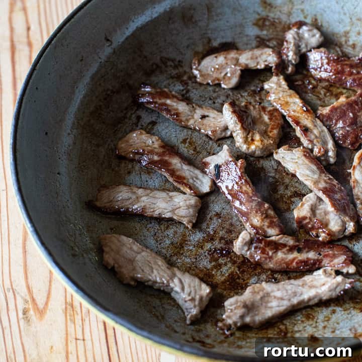 inside shot of a frying pan with strips of caramelised sirloin steak