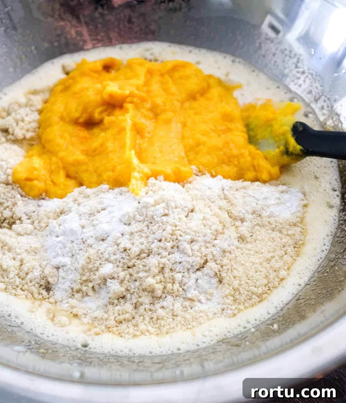 Pureed orange with cake mixture in a bowl, ready to be combined.