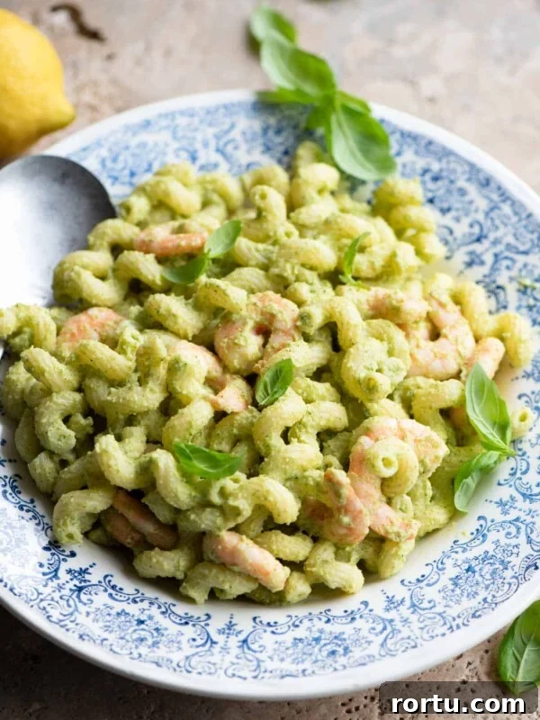 Grilled Summer Vegetables Orzo Salad with Lemon Herb Dressing 5 Zucchini shrimp pasta salad in a blue and white bowl topped with basil leaves.