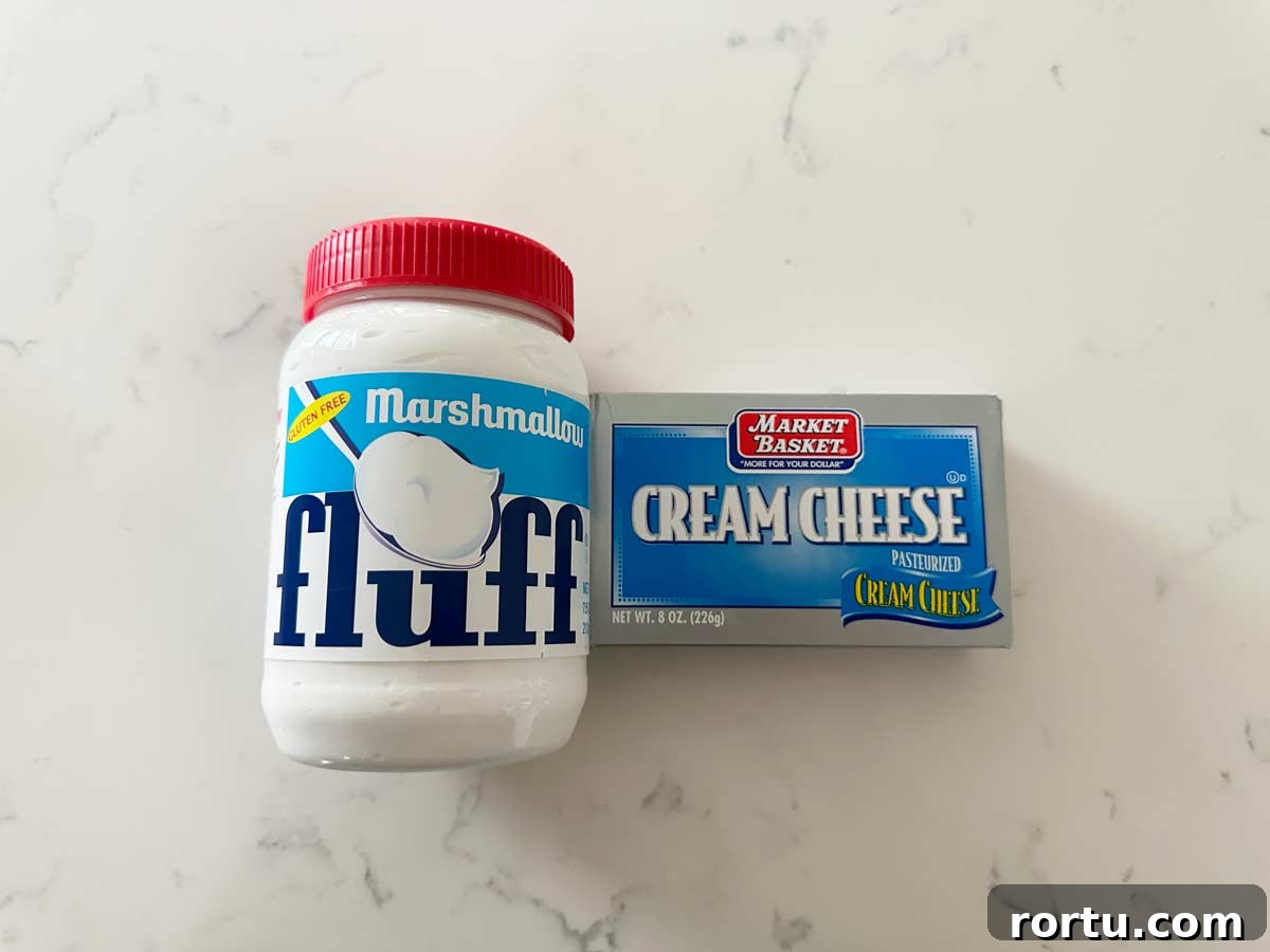 Marshmallow fluff and cream cheese on a white kitchen countertop.