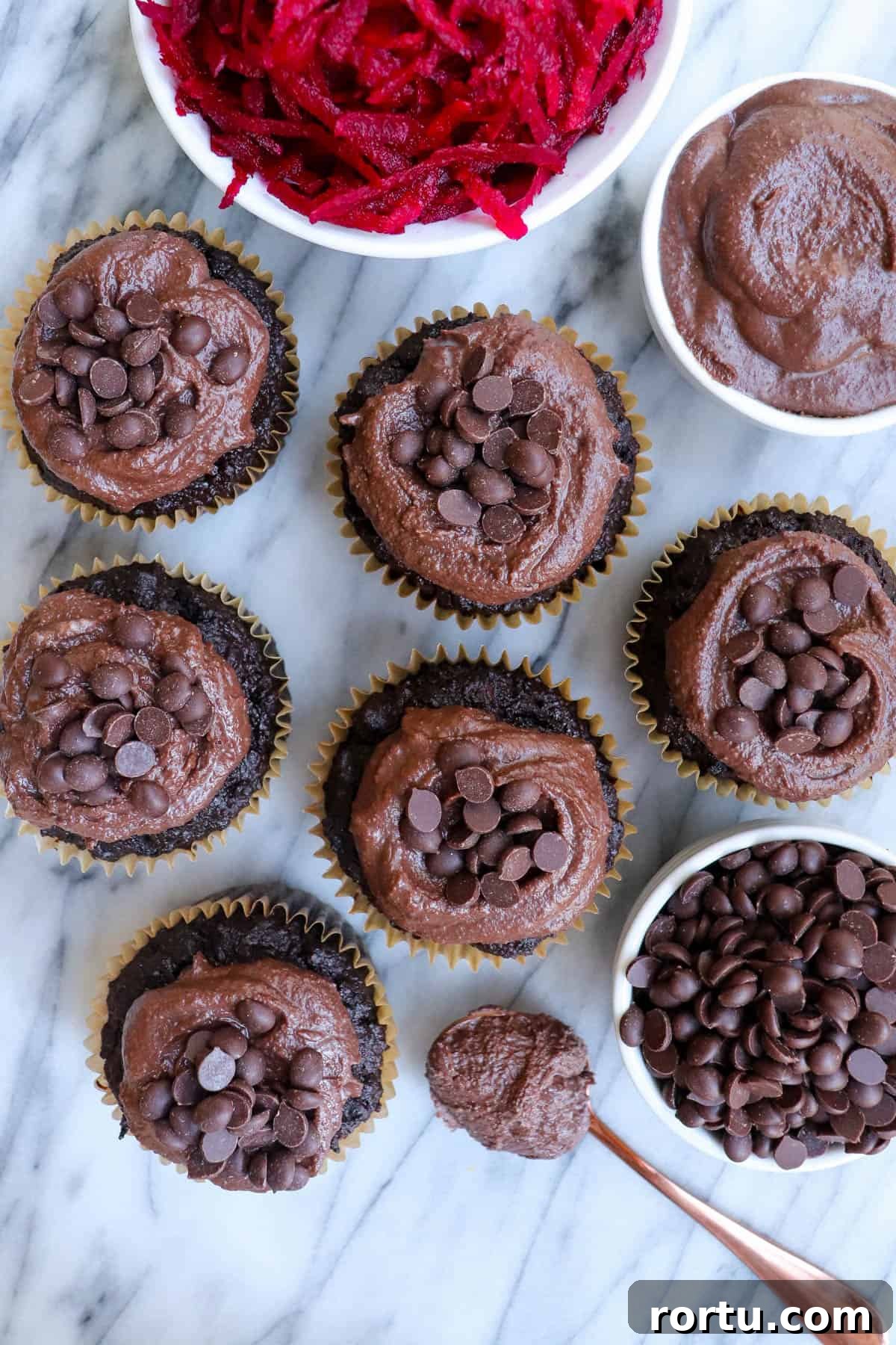 Top view shot of muffins. Bowl of grated beetroot on side for decoration.