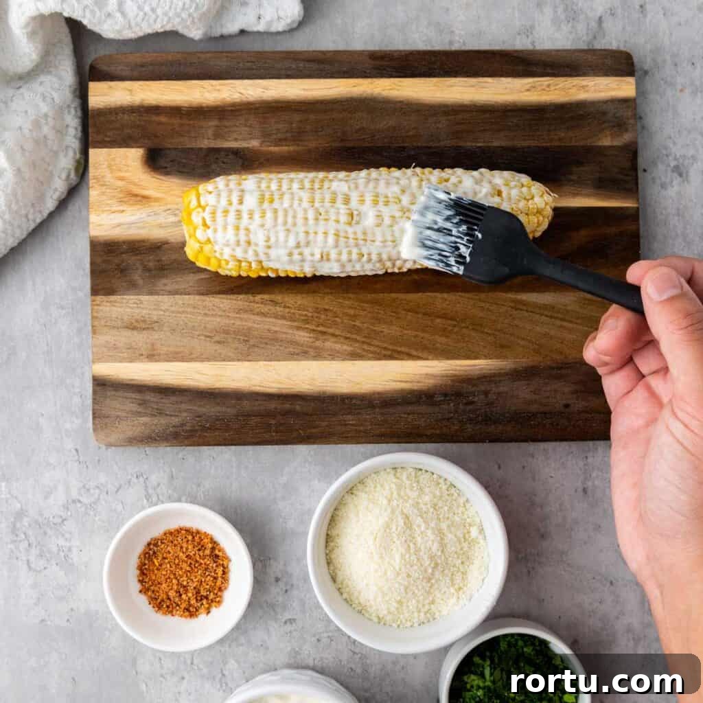 brushing mayonnaise on corn cob