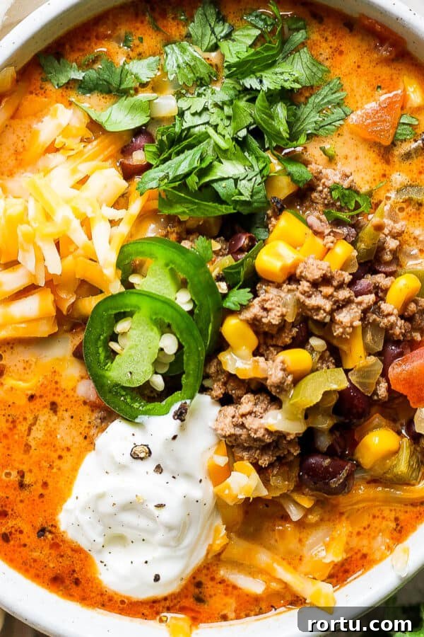Chicken Tortilla Soup Recipe with Crock Pot and Instant Pot Options 11 Top down shot of a bowl of creamy taco soup with jalapeno, cilantro, cheese and sour cream.