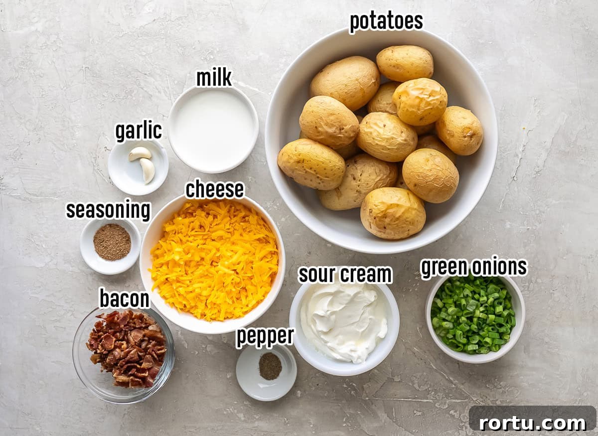 ingredients for Twice Baked Potato Casserole, including whole baked Yukon Gold potatoes, shredded cheddar cheese, sour cream, milk, garlic, seasoning, black pepper, crisp cooked bacon, and chopped green onions arranged in white bowls on a light surface.