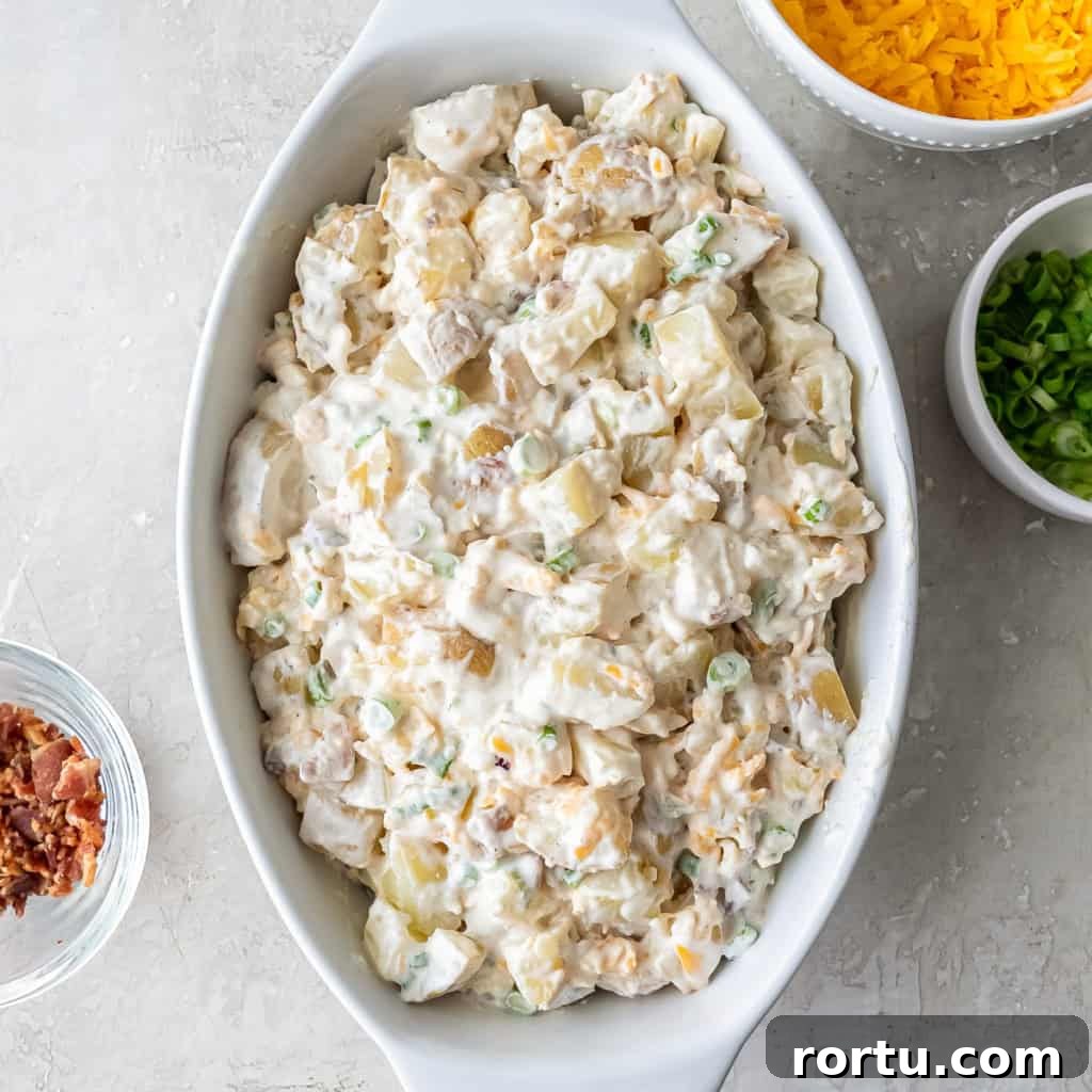Creamy potato mixture spread in a white baking dish before topping.